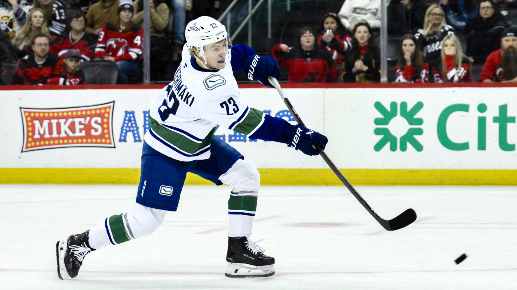 Mar 24, 2025; Newark, New Jersey, USA; Vancouver Canucks right wing Jonathan Lekkerimaki (23) shoots and scores a goal during tovertime shootouts against the New Jersey Devils at Prudential Center. Mandatory Credit: John Jones-Imagn Images