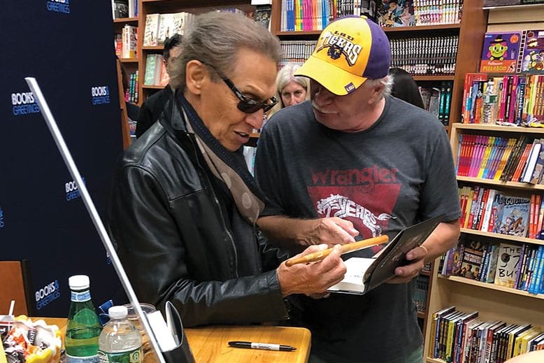 Drummer Alex Van Halen examines his old drumstick, presented to him by a fan who asked him to sign it