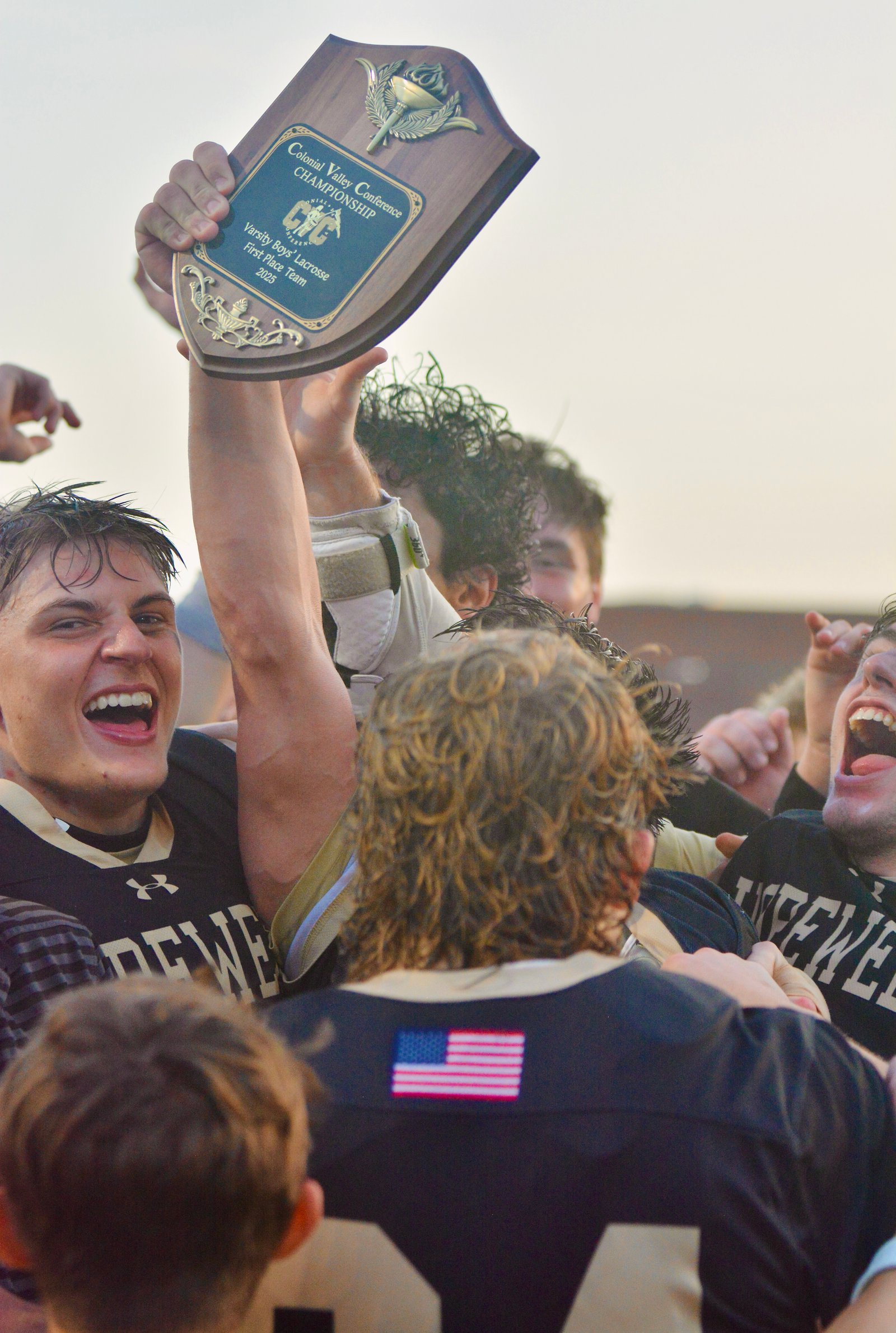 Hopewell Valley players celebrate with the championship trophy after a...