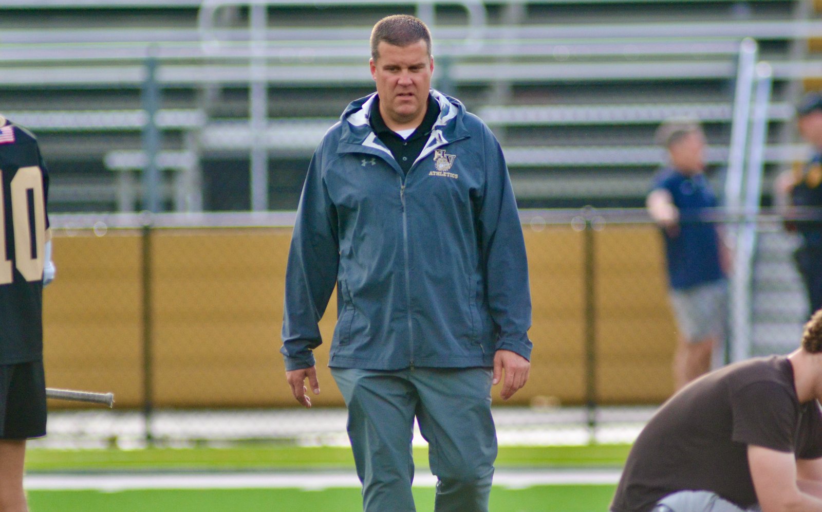 Hopewell Valley athletic director Tripp Becker strides across the field...