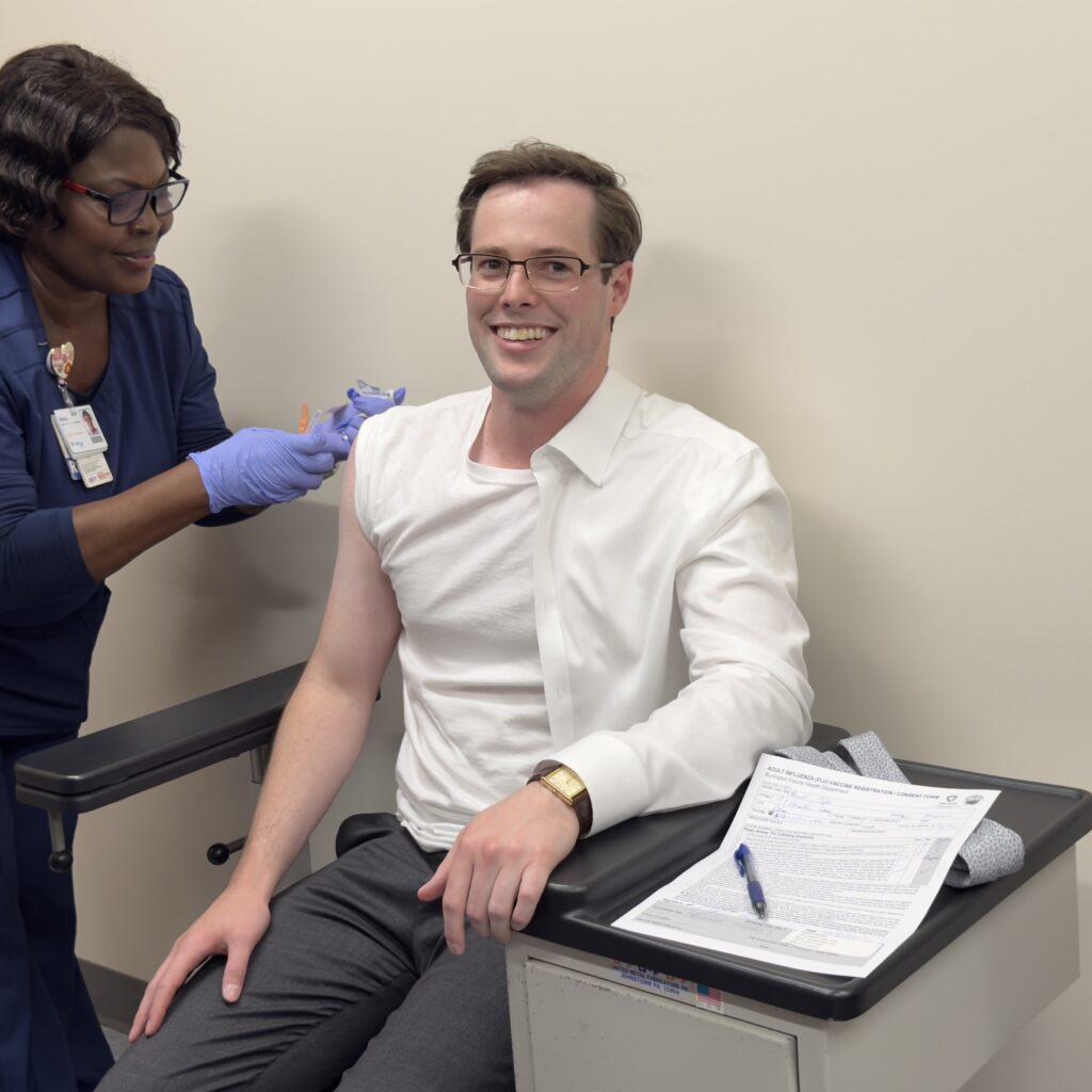 Burlington County Commissioner Tyler Burrell receives a flu shot during...