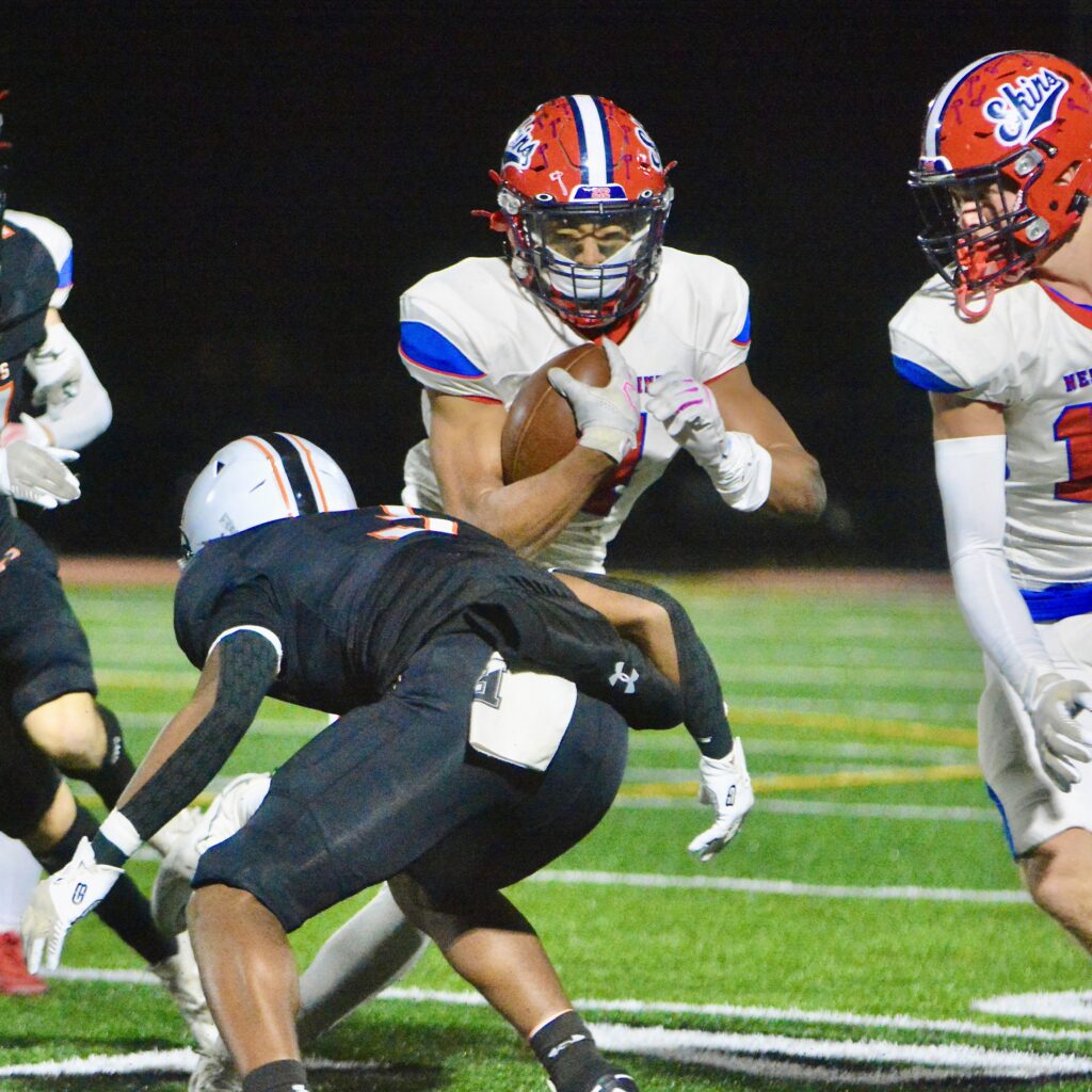 Neshaminy running back Brock Williams, center, carries the ball as...