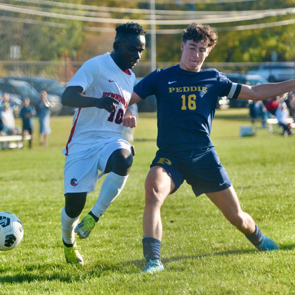 Peddie’s John Giblin, right, tackles the ball out of bounds...