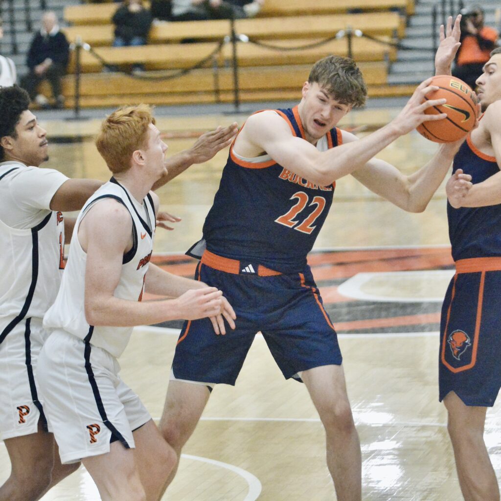 Bucknell’s Amon Dorries, 22, grabs a rebound as he’s surrounded...