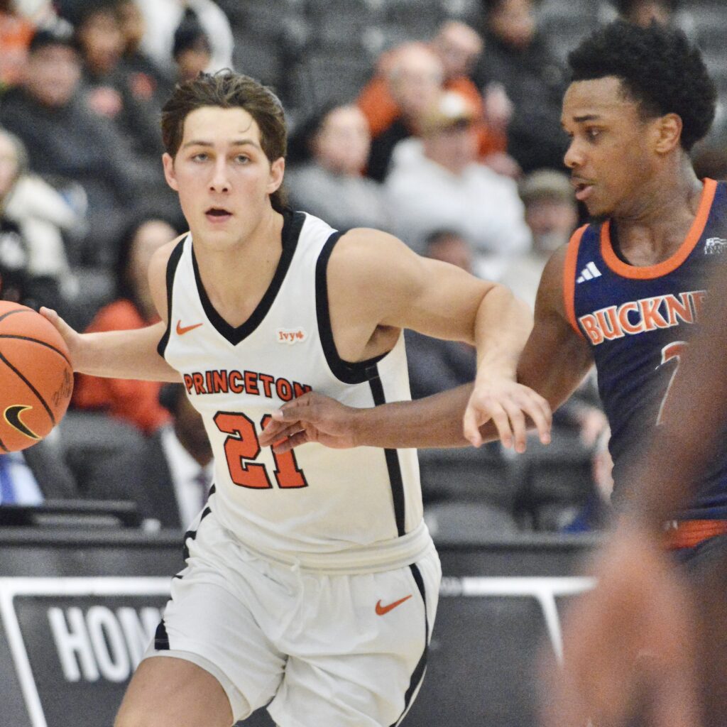 Princeton’s Jack Stanton, left, dribbles the ball up the court...