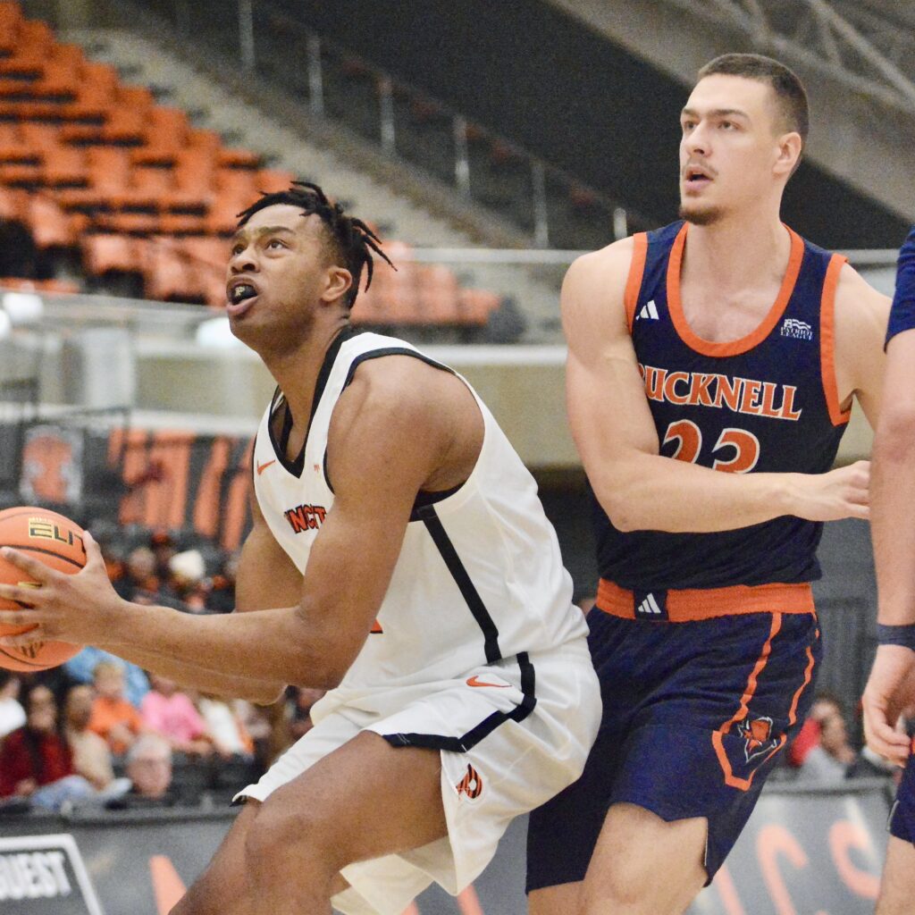 Princeton’s Jacob Huggins, left, goes past Bucknell’s Grgur Brcic, right,...
